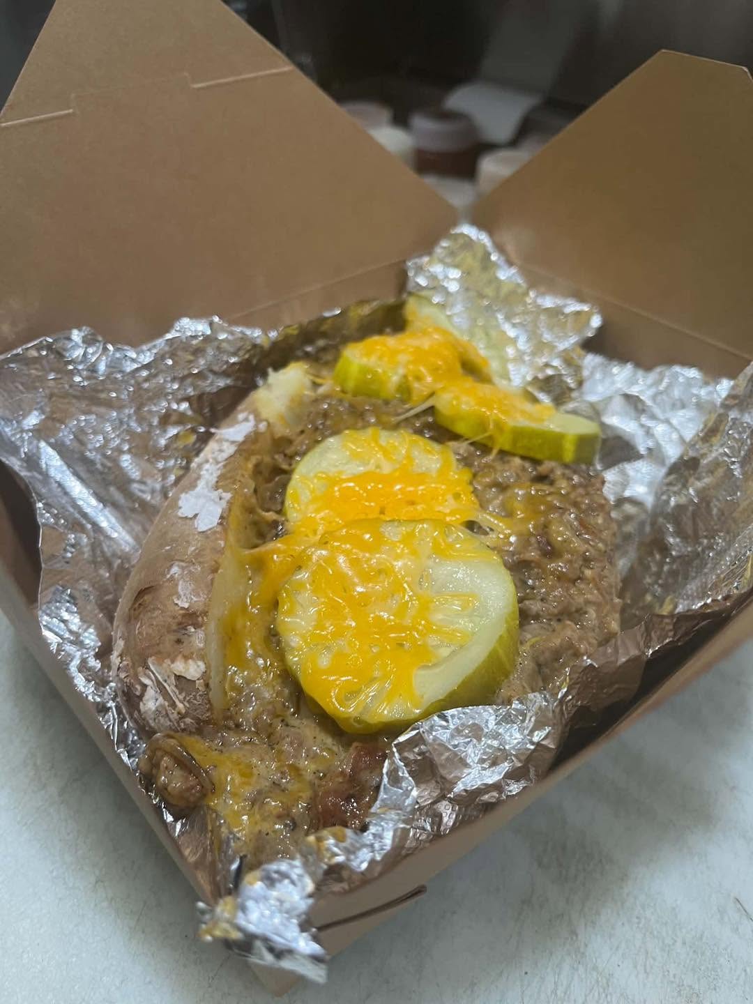 A loaded Big Ass Potato Co. potato with beef, cheese and pickles